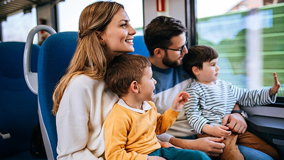 Familie sitzt im Zug und schaut aus dem Fenster