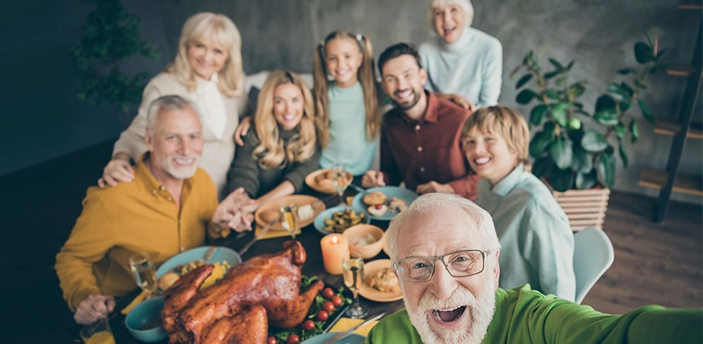 Opa macht Selfie mit der ganzen Familie am koestlichen Tisch